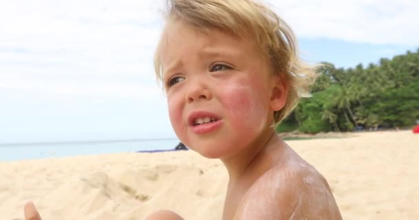 Gondolkodó fiú ül a homokos strandon — Stock videók