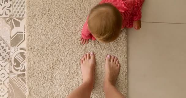 Ребенок с ногами мамы на полу — стоковое видео