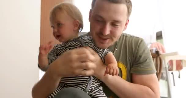 Милый ребенок в руках улыбающегося отца — стоковое видео