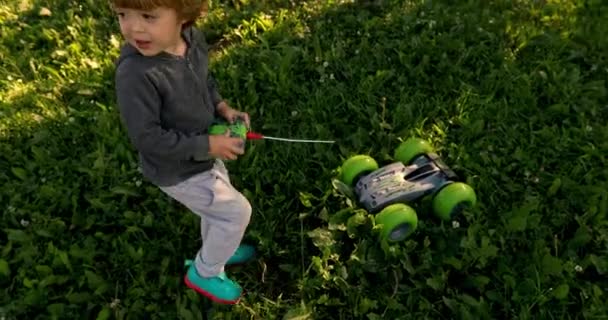 Criança brincando com carro no controle remoto — Vídeo de Stock