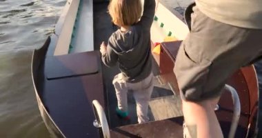 Teknede yürüyen çocuğu elle tutan adam