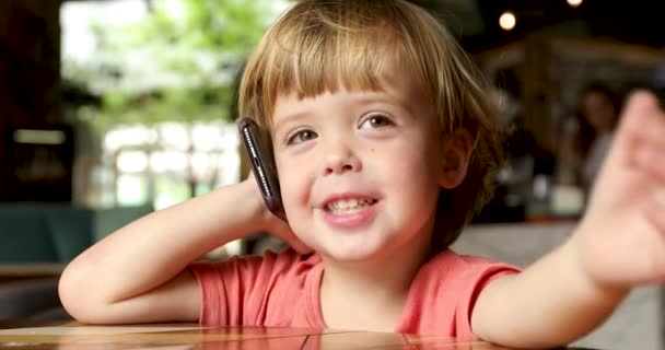 Веселый малыш говорит по мобильному телефону — стоковое видео