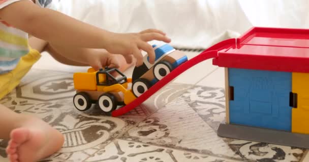 Crop juego de niños con coches de juguete de madera — Vídeos de Stock