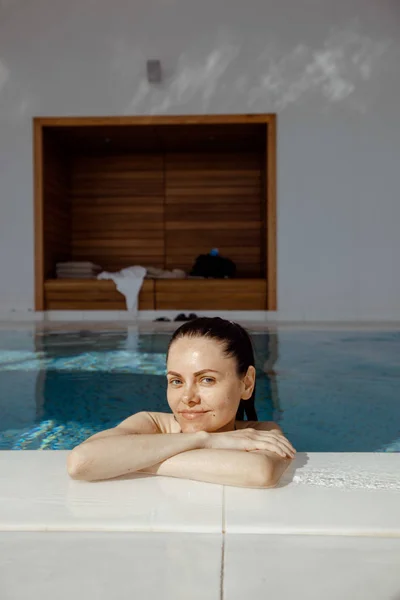 Mujer sonriente descansando en la piscina — Foto de Stock