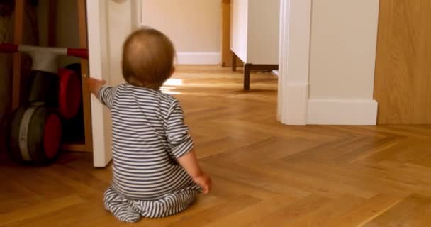 Niño sentado junto a la puerta — Vídeo de stock