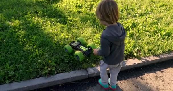 Kid playing with car on remote control — Stock Video
