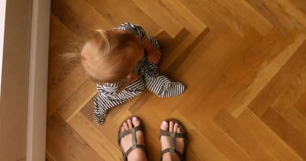 Bebê sentado no chão de madeira — Vídeo de Stock