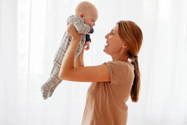 Счастливая семейная мать играет с новорожденным ребенком — стоковое фото