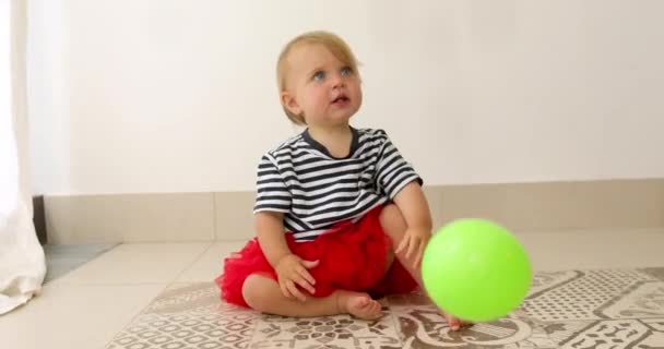 Encantador bebé sentado en el suelo alrededor de globos de colores — Vídeo de stock