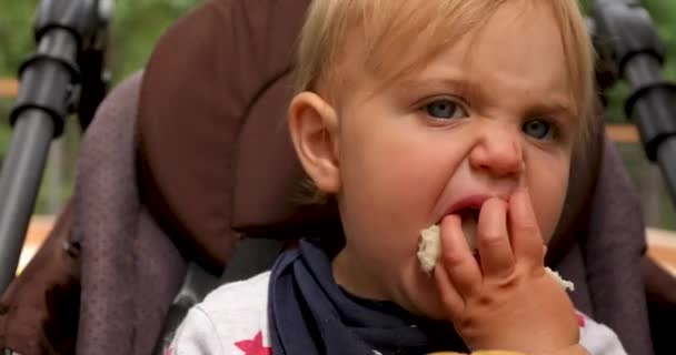 Criança comendo pão na cadeira — Vídeo de Stock