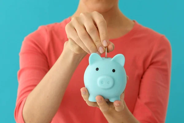 Positive female putting coin in piggybank, planning budget, financial savings — Stock Photo, Image