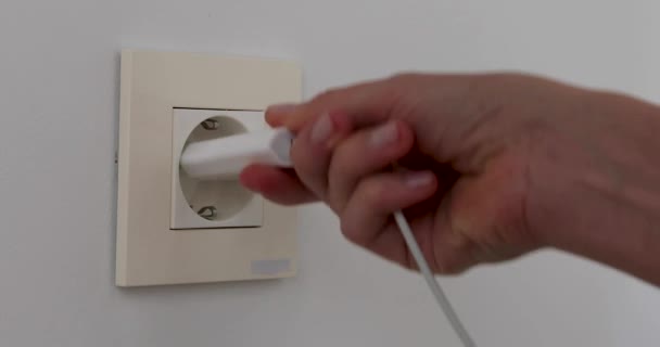 Plugging multiple power plugs into wall outlet — Stock Video