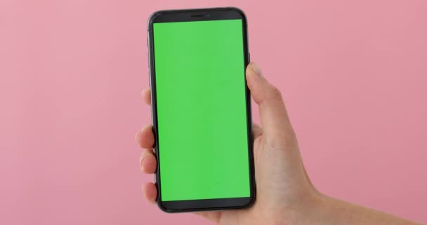 Hand holds a smartphone with greeen screen — Stock Video