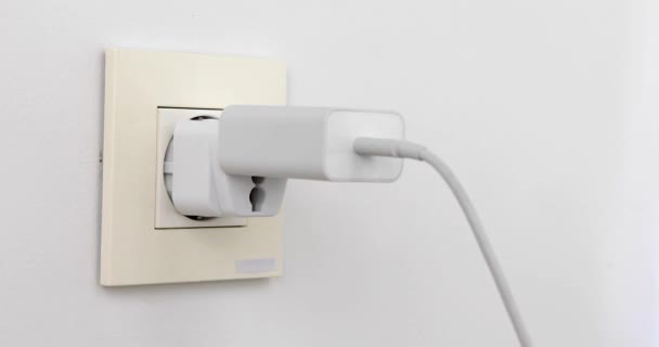 Plugging multiple power plugs into wall outlet — Stock Video