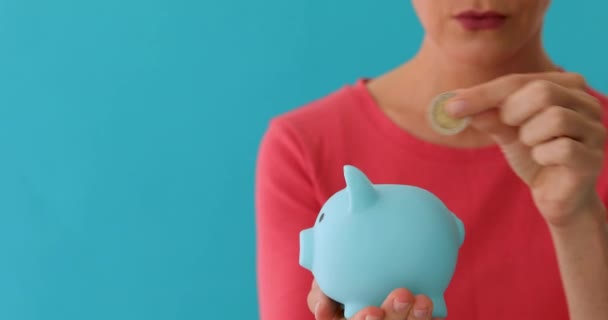 Smiling woman carrying piggy bank — Stock Video