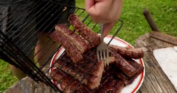 Неузнаваемый человек снимает приготовленное мясо с гриля — стоковое видео