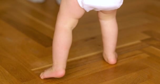 Piedi che camminano sul pavimento. Primo piano della passeggiata per l'apprendimento dei bambini — Video Stock