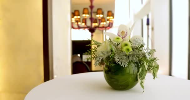 Квіткова композиція в круглій вазі на столі — стокове відео