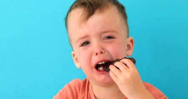 Liten pojke är upprörd att äta choklad — Stockfoto