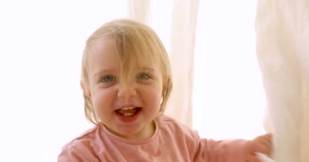 Nettes kleines Mädchen versteckt sich hinter einem Vorhang — Stockvideo