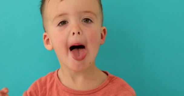 Нахабна дитина стирчить язиком на камеру — стокове відео