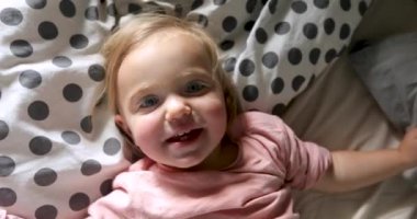 Sevimli çocuk evde yatakta haddeleme