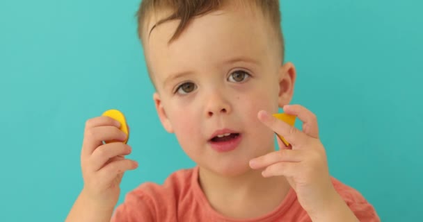 Умный ребенок, показывающий жёлтые геометрические фигуры на камеру — стоковое видео