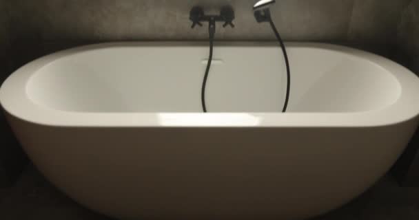 Modern acrylic soaking bathtub with hand shower — Stock Video