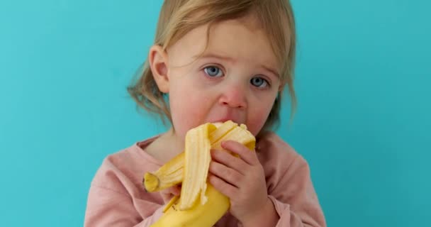 Dziewczynka je banana. — Wideo stockowe
