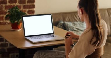 Ekin kadın evde dizüstü bilgisayar kullanıyor.