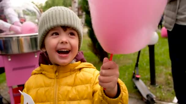 Menino comendo fio dental de doces no parque — Vídeo de Stock