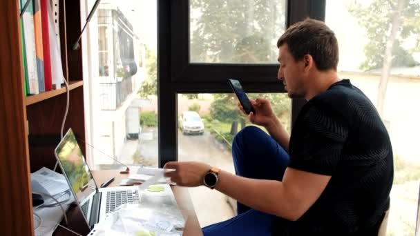 Man beschouwt papieren smartphone en laptop — Stockvideo