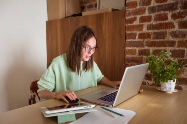 Evde dizüstü bilgisayar kullanan bir kadın.