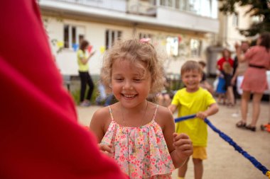 Arkadaşlarıyla parkta neşeli bir kız.
