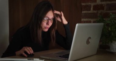 Gece çalışan bir kadın dizüstü bilgisayar kullanıyor.