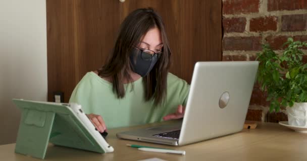 Mujer enmascarada trabajando de noche usando laptop — Vídeo de stock