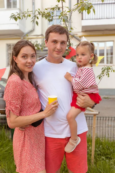 Positive young family with kid standing on street — Stock Photo, Image