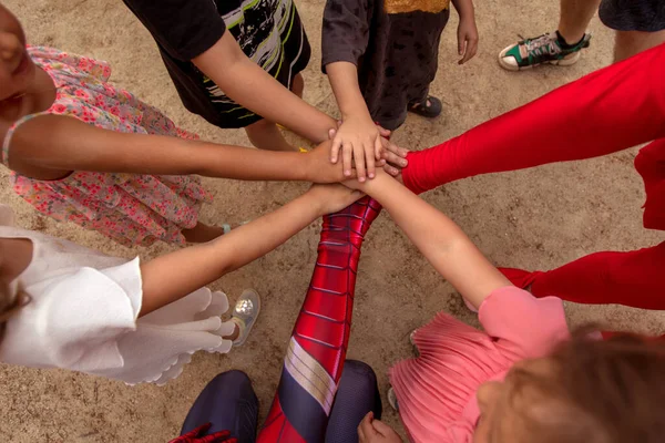 Grupo de crianças empilhando as mãos juntas — Fotografia de Stock