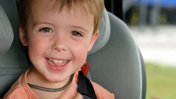 Enfant souriant assis sur le siège d'auto — Photo