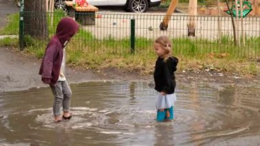 Su birikintisinde oynayan çocuklar