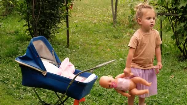 Dívka hraje s panenkou v parku — Stock video