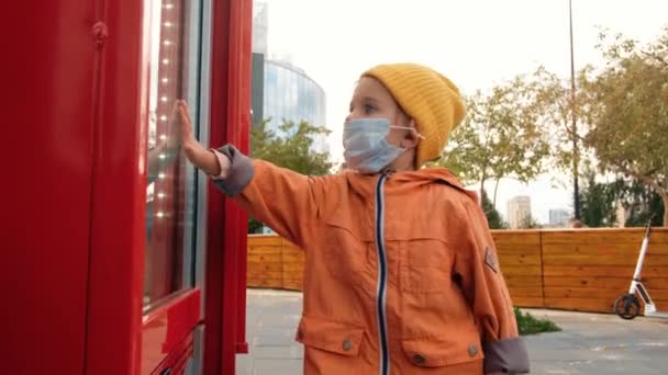 Enfant en masque touchant fenêtre — Video