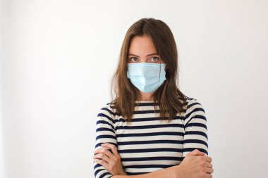 Mavi tıbbi koruyucu maskeli kadın durmak istiyor.