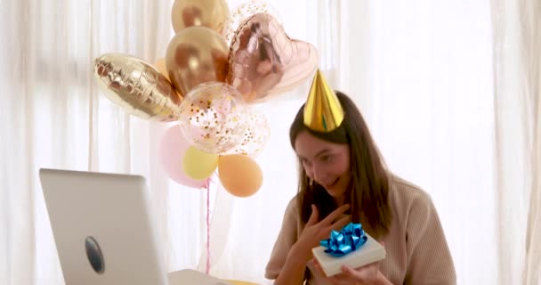 Woman opens gift in front of birthday laptop — Stock Video
