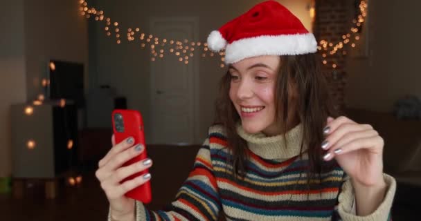 Εορταστική κυρία μιλάει σε video call κρατώντας το smartphone closeup — Αρχείο Βίντεο