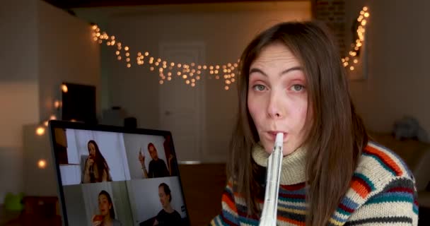 Vrouw blaast party horn vieren verjaardag in video-chat — Stockvideo