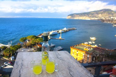 Sorrento, İtalya - 7 Mart 2018: Şişe ve geleneksel İtalyan likör limon ile iki bardak - Lemonchello - Sorrent'ın sahil arka plan üzerinde 
