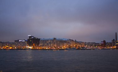 Helsinki, Finlandiya - 3 Ocak 2018: Helsinki, Finlandiya başkenti suda geceleri yansıtan Rıhtımlar boyunca geleneksel binalar