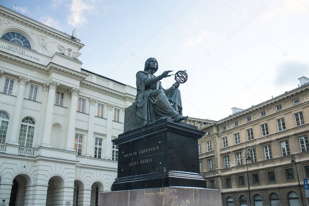 Warsaw, Poland - February 24, 2018: Monument to Nicholas Copernicus (1830) by Bertel Thorvaldsen holding a compass and armillary sphere in front of Academy of Science in Warsaw 