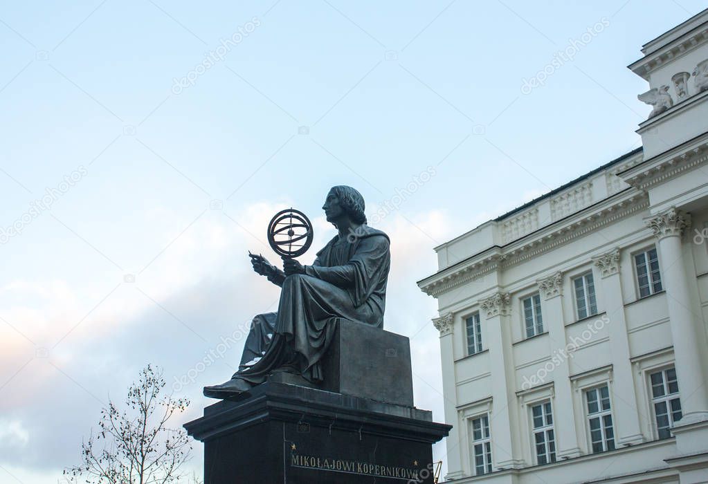Warsaw, Poland - February 24, 2018: Monument to Nicholas Copernicus (1830) by Bertel Thorvaldsen holding a compass and armillary sphere in front of Academy of Science in Warsaw 